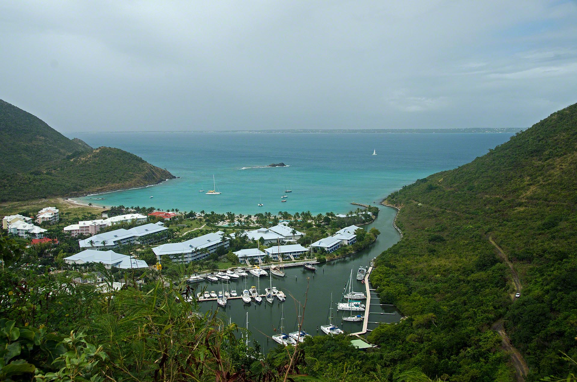 Turquoise Anse Marcel bay and marina framed by green hills on Saint Martin.